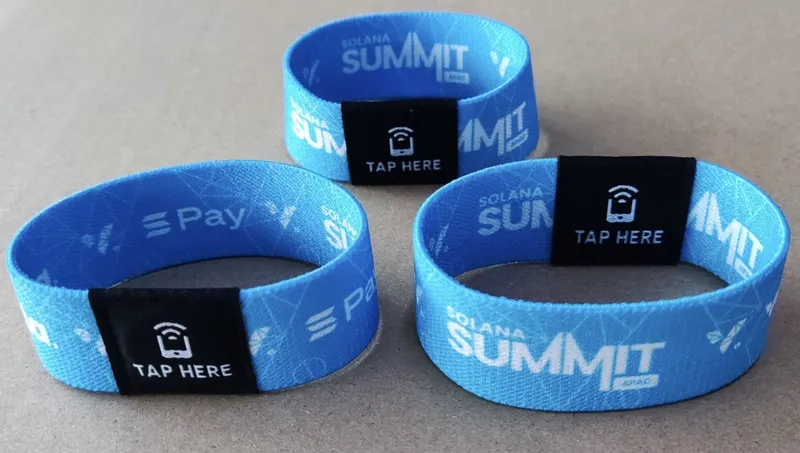 Three blue NFC wristbands with 'Tap here' patches